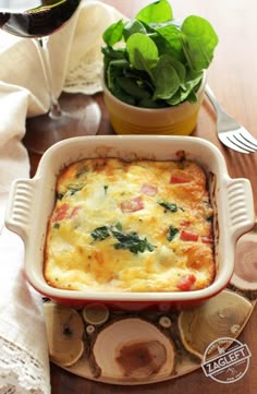 a casserole dish with spinach and cheese in it on a wooden table