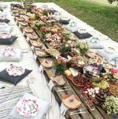 a long table covered in lots of different types of foods and flowers on top of it