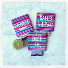 three colorful striped personalized flasks with lime slice on marble counter top next to it