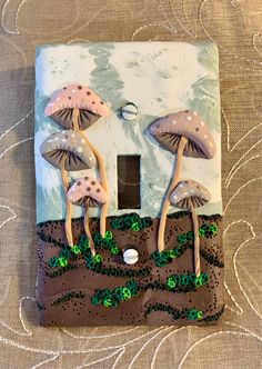 a decorative light switch cover with mushrooms on it