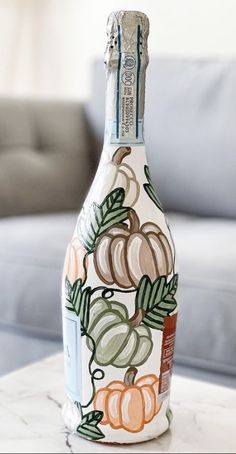 a painted bottle sitting on top of a marble table in front of a gray couch