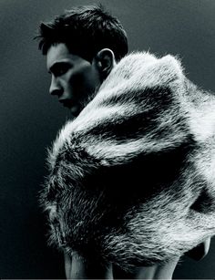 black and white photograph of a man wearing a fur coat