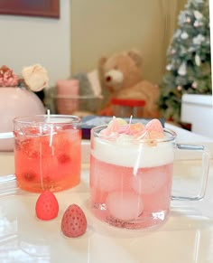 two glasses filled with liquid sitting on top of a table next to a teddy bear