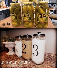 four jars filled with pickles sitting on top of a counter next to each other