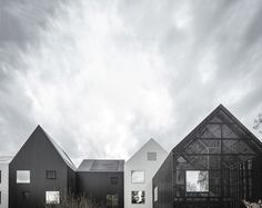 three black and white houses are shown against the cloudy sky