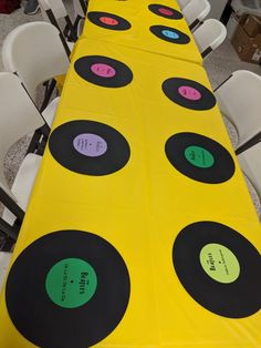 a long table covered in yellow and black records