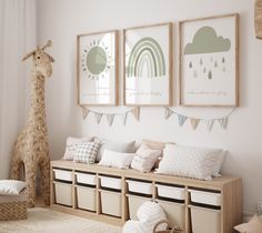 a room with some pictures on the wall and stuffed giraffe in the corner