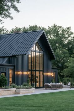 a black house with large windows and lots of grass