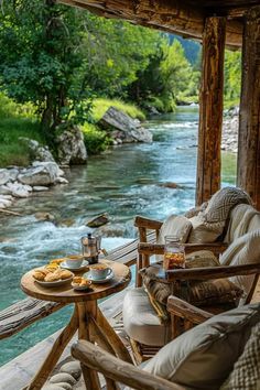 two chairs and a table on a porch overlooking a river