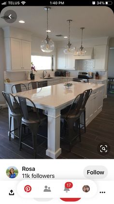 a large kitchen with an island in the center and chairs around it, along with two bar stools