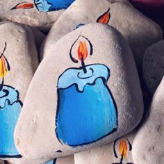 painted rocks with lit candles on them