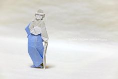 an origami man standing in the snow with his hands on his hips and legs crossed