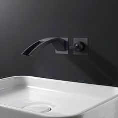 a white sink sitting under a faucet next to a wall mounted soap dispenser