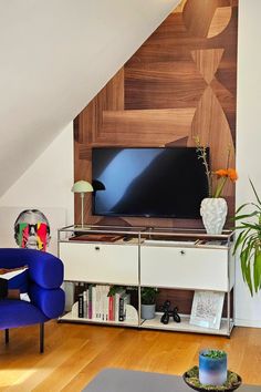 a living room with an entertainment center and blue chairs