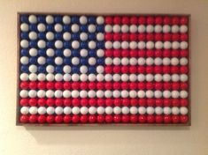 an american flag made out of white and red beads is hanging on the wall next to a toilet