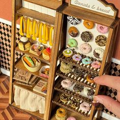 a miniature display case filled with lots of donuts and other pastries on shelves