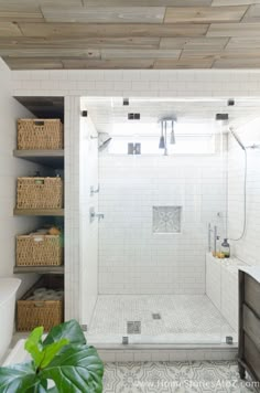 a bathroom with white tile and wood ceilinging, including a walk - in shower