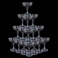 a stack of wine glasses sitting next to each other on top of a black background