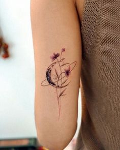 a woman's arm with a tattoo on it that has flowers in the center