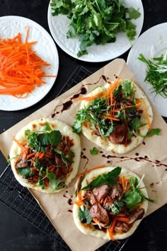 three pita breads topped with meat and veggies on top of a table