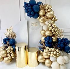 a table topped with gold and blue balloons