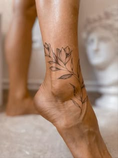 a close up of a person's foot with a flower tattoo on it