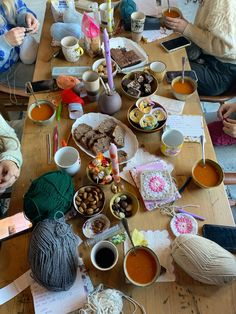 a group of people sitting around a table covered in food