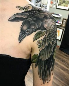 a woman with a black bird tattoo on her shoulder