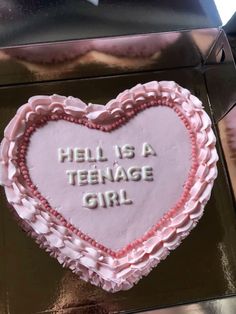 a cake shaped like a heart with the words hell is a teenage girl written on it