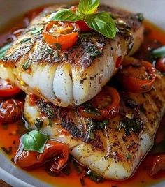 some fish and tomatoes on a plate with sauce