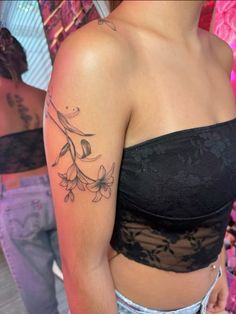 a woman with a tattoo on her left arm and shoulder is looking at the camera