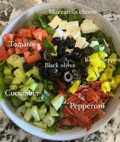 a salad with olives, tomatoes, cucumber, and black olives