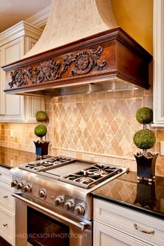 a stove top oven sitting inside of a kitchen next to white cabinets and counter tops