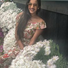 a woman sitting in front of white flowers