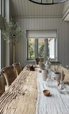 a dining room table with dishes and vases on it