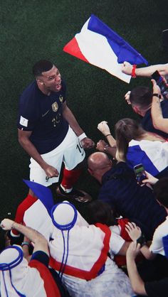 a soccer player is surrounded by fans and photographers