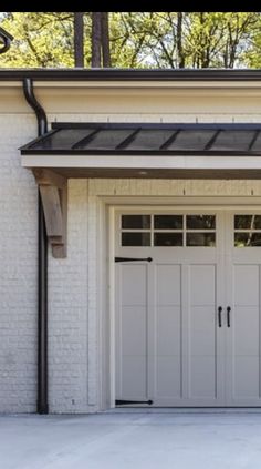 two garage doors are open in front of a white brick building