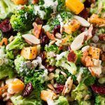 a salad with broccoli, cranberries and almonds in a bowl