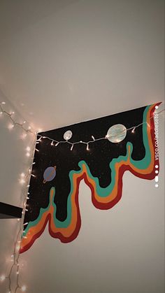 an image of a space themed banner hanging on the wall with string lights and decorations