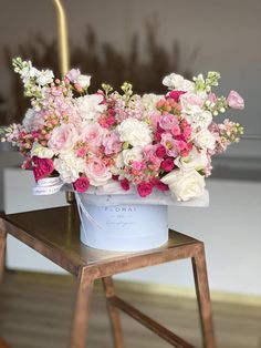 pink and white flowers in a bucket on a table