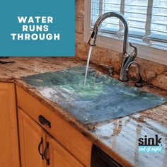 a kitchen sink with water running through the faucet and on top of it