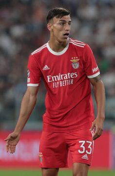 a soccer player is looking at the ball in his hand as he stands on the field