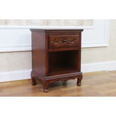 a small wooden cabinet sitting on top of a hard wood floor next to a wall