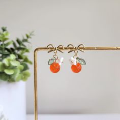 We have silver version available, please contact seller for detail. Our cute glass orange earrings are made with Czech glass orange, glass flower, acrylic leaf and 14k gold plated hooks/studs which are good for delicate ears. Size: the hook style is about 0.6" wide and 1.35" long the stud style is about 0.6" wide and 1" long Handmade Apricot Earrings Perfect For Gifts, Handmade Apricot Earrings For Gift, Cute Nickel-free Orange Jewelry, Trendy Orange Dangle Earrings, Trendy Orange Drop Earrings, Trendy Handmade Orange Earrings, Cute Orange Dangle Jewelry, Apricot Drop Earrings For Gifts, Trendy Orange Round Earrings