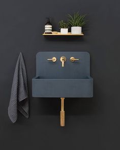 a blue sink sitting next to a shelf with towels and plants on top of it