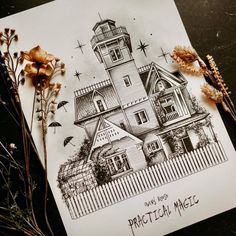 a drawing of a house on top of a piece of paper next to dried flowers