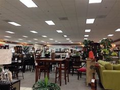 the inside of a furniture store with tables, chairs and couches in it's center