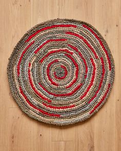 a round rug on the floor with red and grey circles