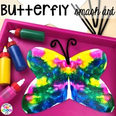 the butterfly smash art tray is filled with paints and crayons