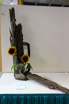 there is a vase with sunflowers in it on top of a white table